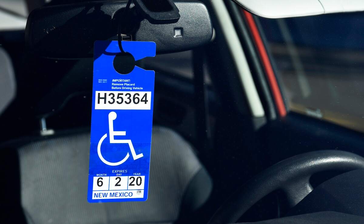 Handicapped parking placard on the rearview mirror of a car; handicap parking permit