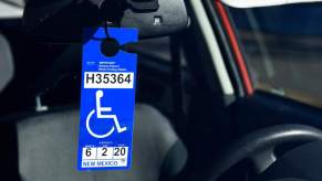 Handicapped parking placard on the rearview mirror of a car; handicap parking permit