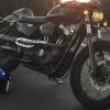 A black Harley-Davidson Sportster XL1200N shows off its custom work on a California beach.