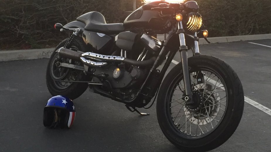 A black Harley-Davidson Sportster XL1200N shows off its custom work on a California beach.