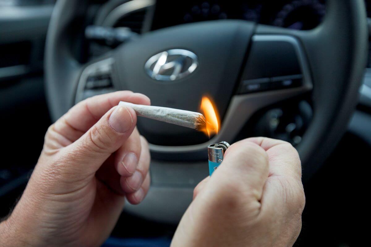 A driver in a Hyundai car lighting a marijuana cigarette to symbolize drug driving laws