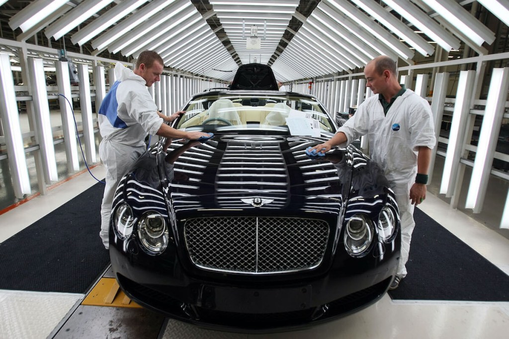 Two factory workers clean a new Bentley