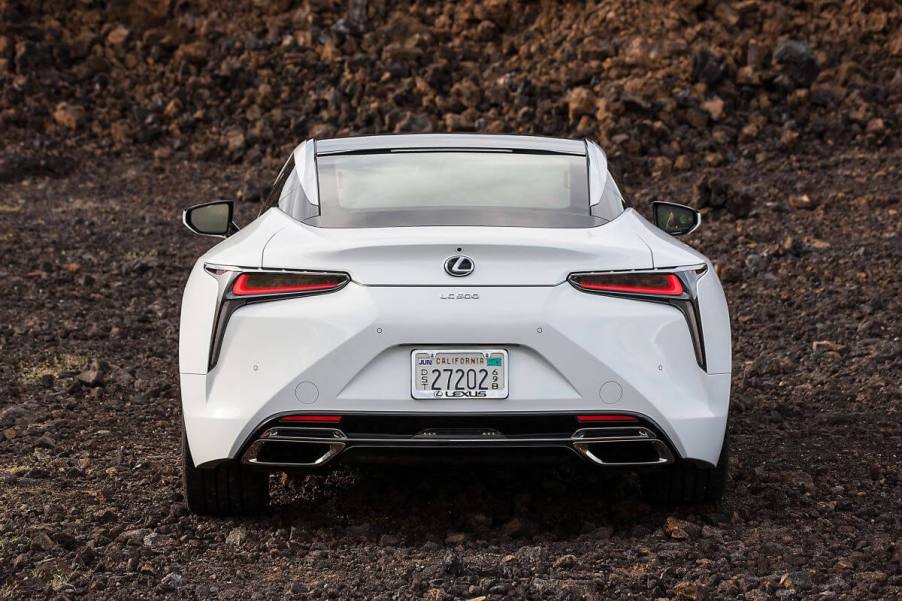 A rear shot of the trunk, bumper, and taillights on a 2024 Lexus LC 500 grand tourer parked on clumps of dirt