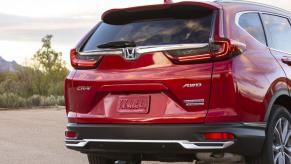 An exterior rear shot of a 2023 Honda CR-V Hybrid Touring AWD model where a spare tire is found in the trunk