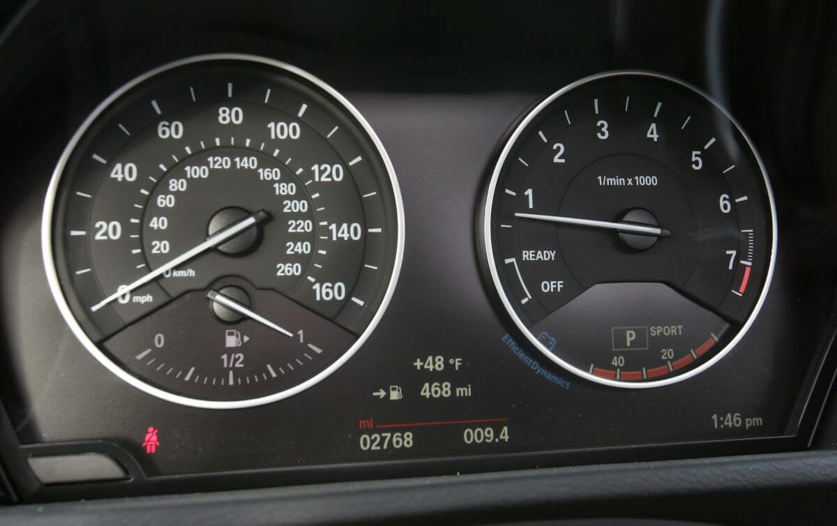 The interior of a 2016 BMW X1 featuring a driver's display with a speedometer (L) and tachometer (R)