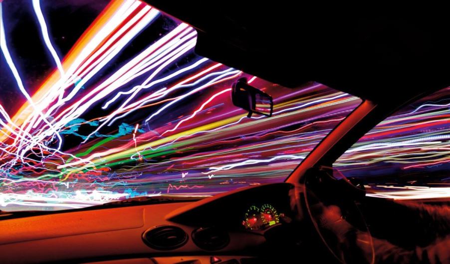 The streaks and trails of traffic and night lights from inside a moving car from throttle control