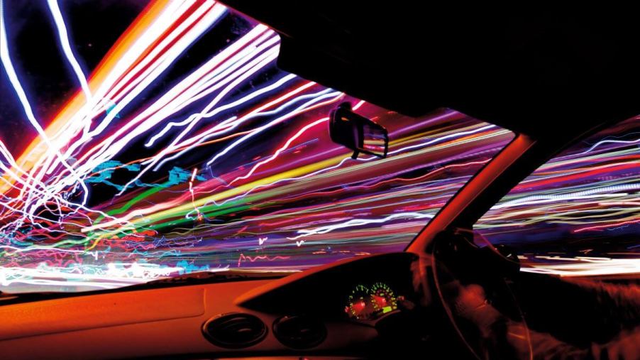 The streaks and trails of traffic and night lights from inside a moving car from throttle control