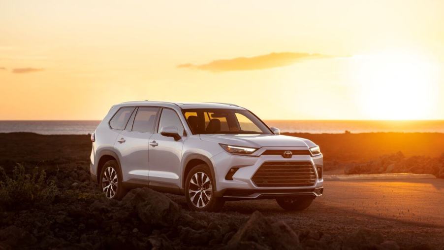 A 2024 Toyota Grand Highlander Limited midsize SUV model parked in the wild as the sun sets behind it