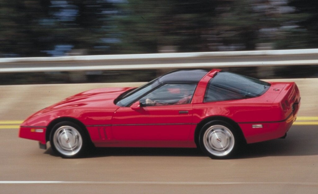A red C4 Corvette ZR-1 from the post-1992 years flies down a banked stretch of road.