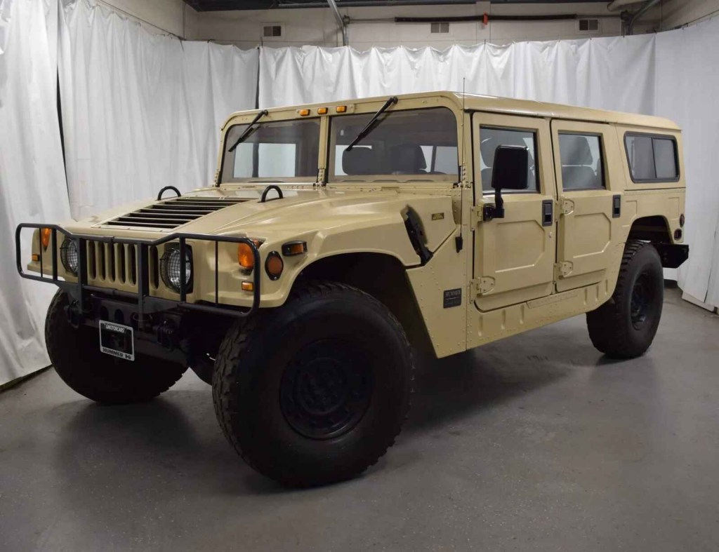 A tan 1992 Hummer H1 Humvee parked at a left front angle