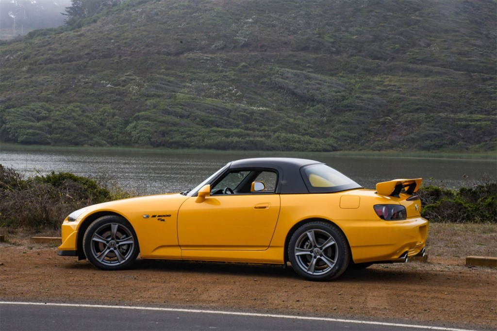 Yellow 2009 Honda S2000 CR parked in front of a river