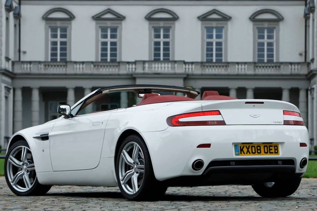 A white Aston Martin Vantage Convertible shows off its drop top. 
