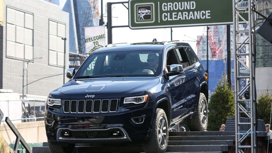A 2016 Jeep Grand Cherokee doing an demonstration at an auto show.