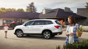 White 2017 Honda Pilot SUV with family and house