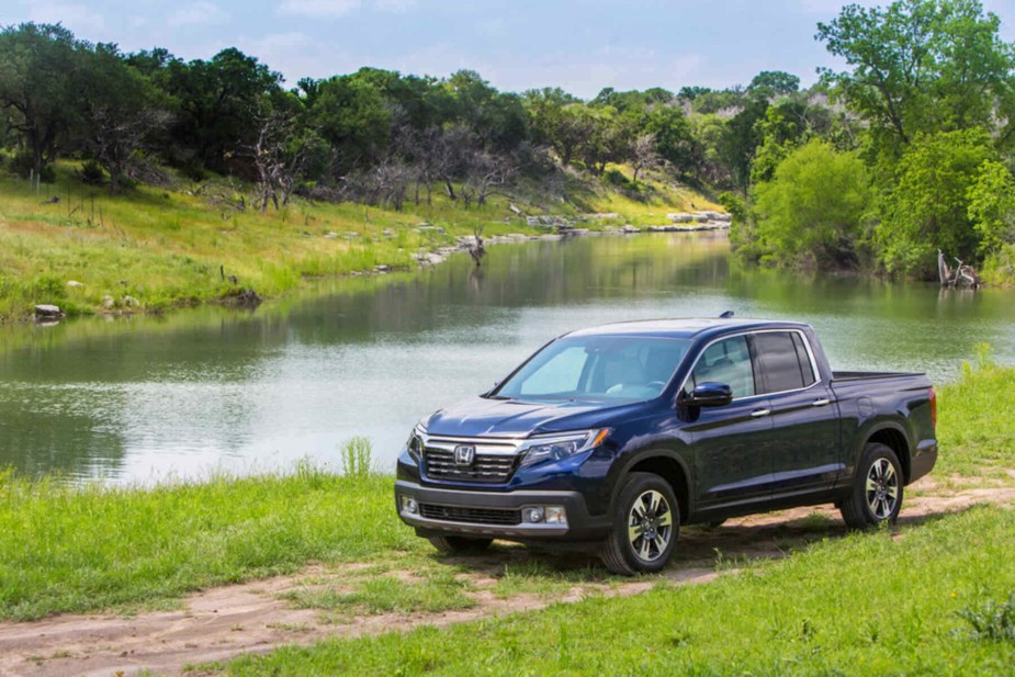 A dark blue 2018 Honda Ridgeline model on a trail near a river was the safest pickup truck. 