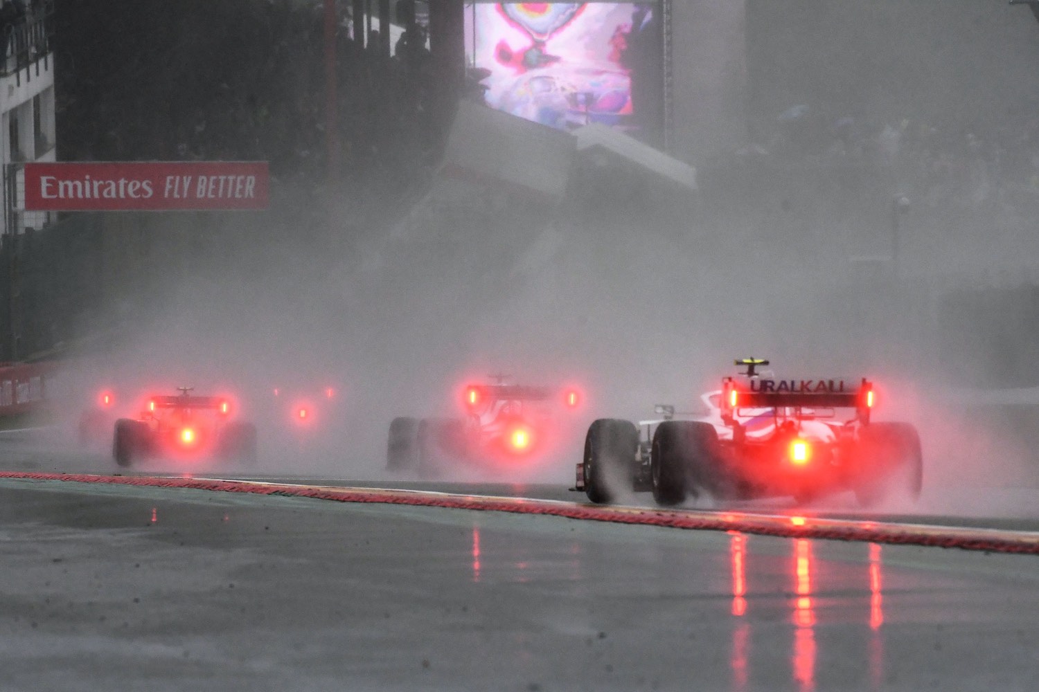 The tail lights of three Formula 1 cars in the rain during the 2021 Belgian Grand Prix