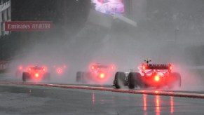 The tail lights of three Formula 1 cars in the rain during the 2021 Belgian Grand Prix