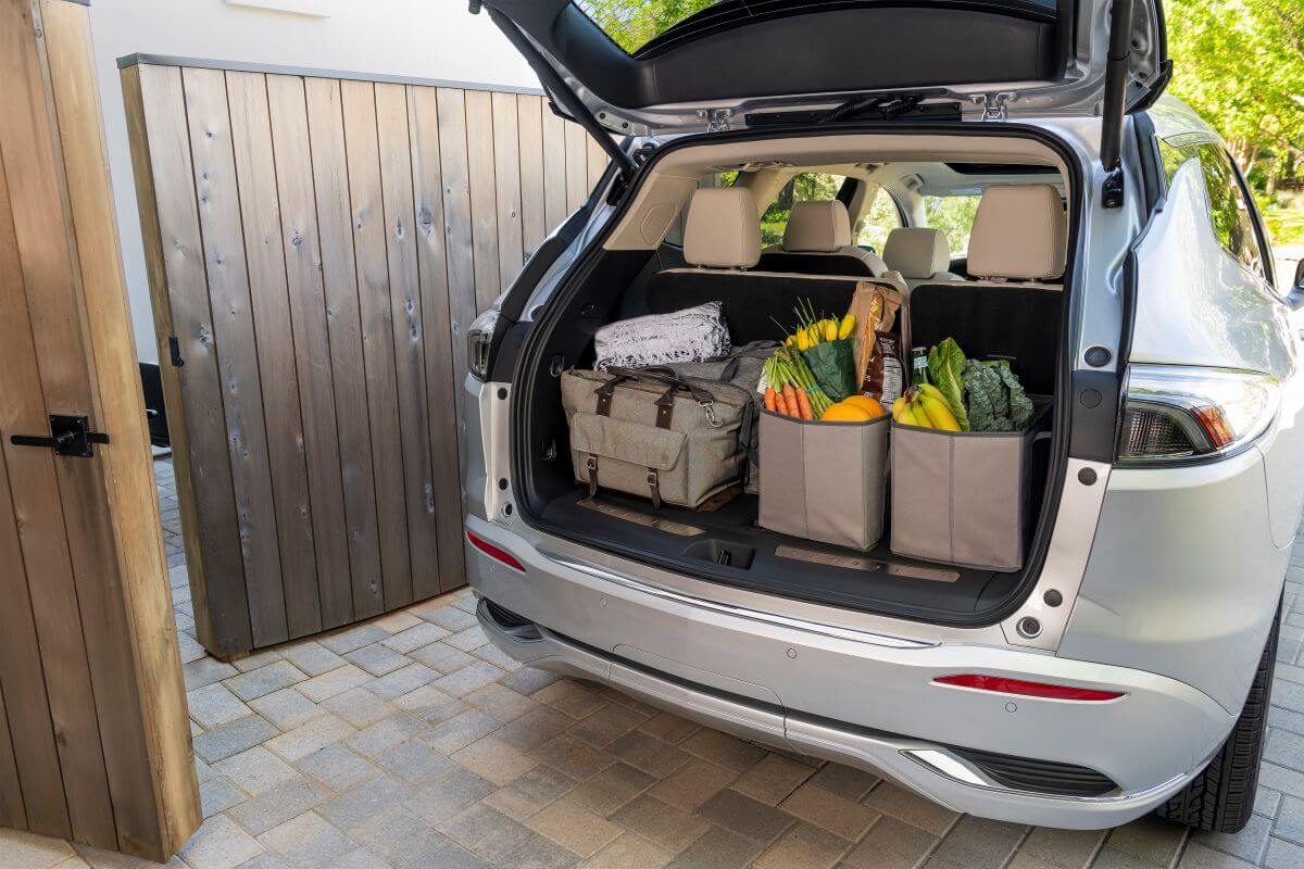 A cargo space filled with grocery bags with an open power liftgate on a 2022 Buick Enclave Avenir