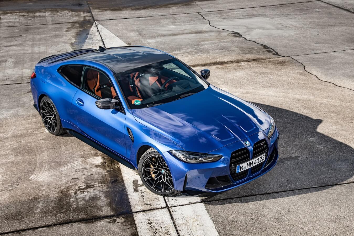 Overhead shot of blue 2023 BMW M4 parked on a racetrack.
