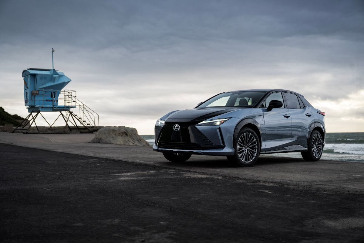 A 2023 Lexus RZ 450e Luxury all-electric SUV model in Ether Black parked on an overcast beach