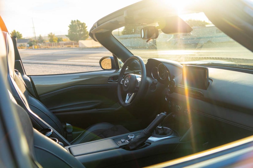 Interior of 2023 Mazda Miata RF shot from passenger side during sunset with top down