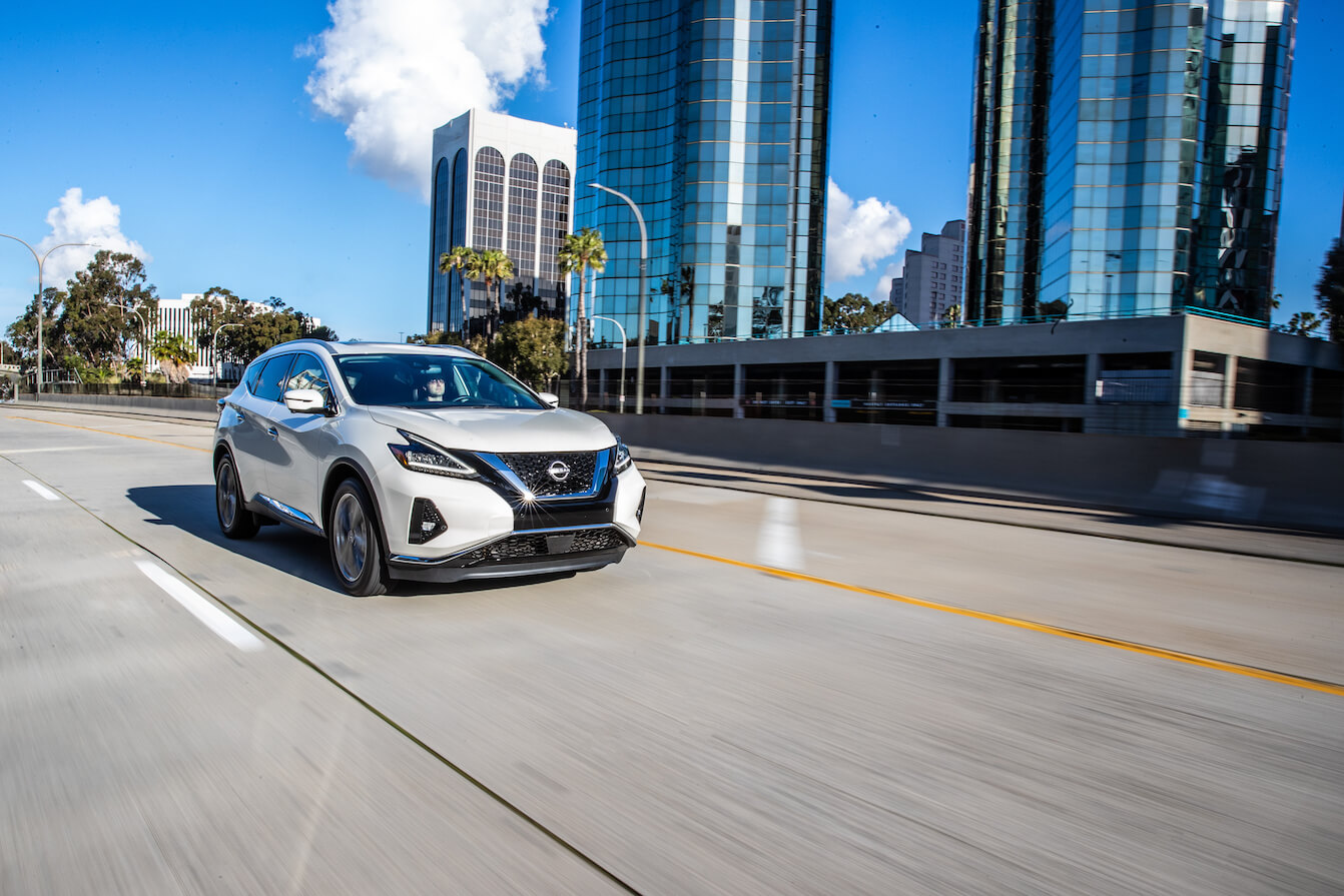 2023 Nissan Murano in white driving on a city highway. The 2023 Nissan Murano's performance makes it well-suited for the task.