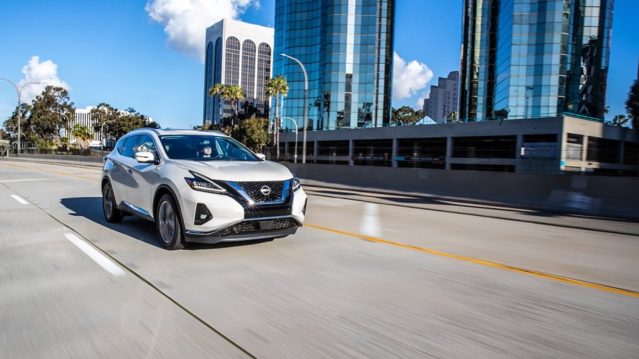 2023 Nissan Murano in white driving on a city highway. The 2023 Nissan Murano's performance makes it well-suited for the task.