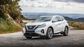 A white 2023 Nissan Murano driving on a mountain. Nissan Murano sales are lagging this year.