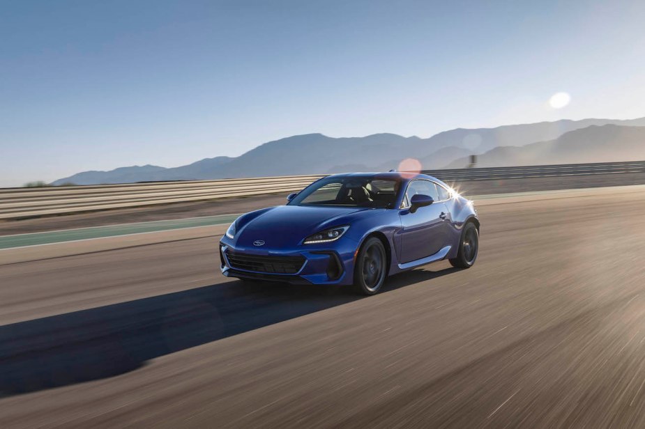 A blue 2023 Subaru BRZ driving down a track road. This is one of the premier sports cars on the market.