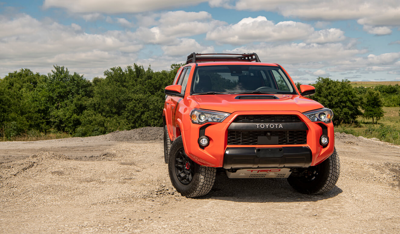 An orange 2023 Toyota 4Runner parked on top of a cliff. The 2023 Toyota 4Runner price is a major consideration when buying.
