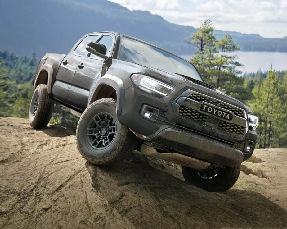 A Toyota Tacoma truck navigating an off-road obstacle. 