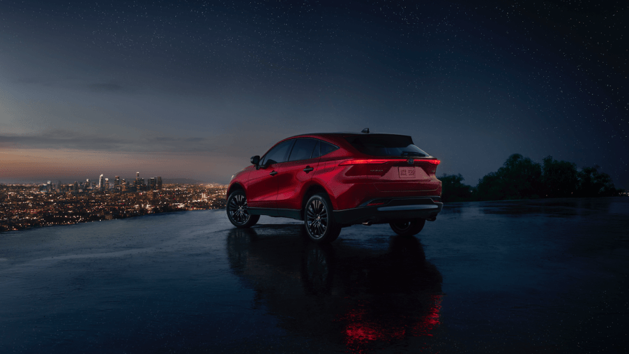 The rear shot of a 2023 Toyota Venza Nightshade overlooking the city at night on a cliff. The Toyota Venza's resale value is pretty high.