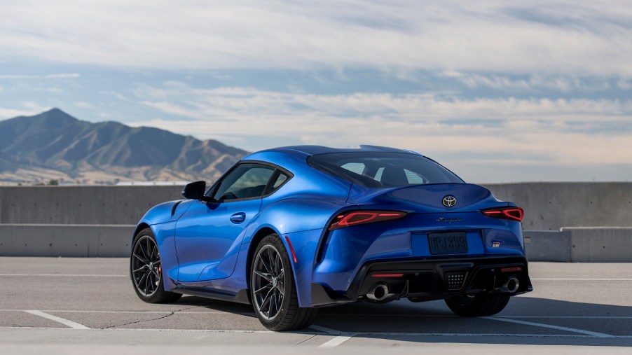 A blue 2023 Toyota Supra parked outside in left rear quarter view with a mountain in the background