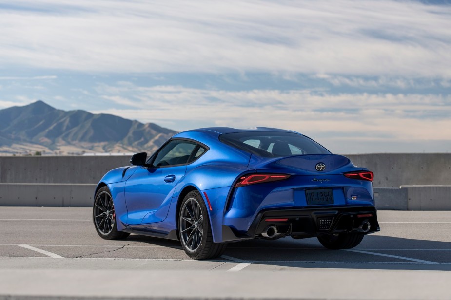 A blue 2023 Toyota Supra parked outside in left rear quarter view with a mountain in the background