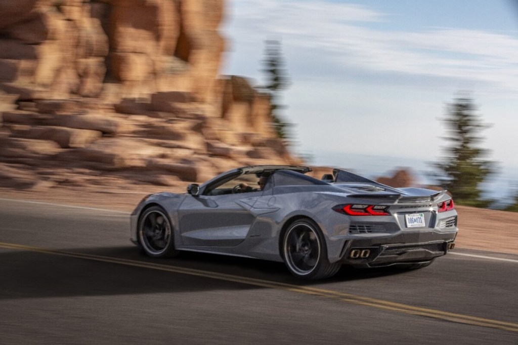 A gray 2024 Chevrolet Corvette E-Ray Hybrid drives on a coastal highway.