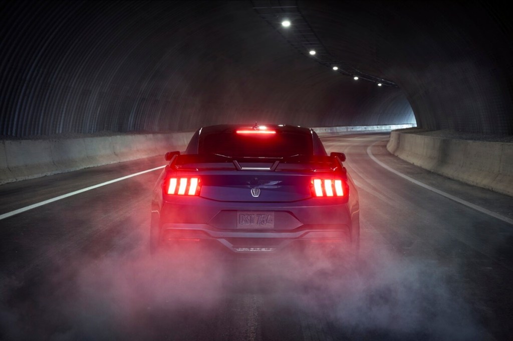 A new 2024 Ford Mustang Dark Horse in a dark tunnel with rear lights illuminated.
