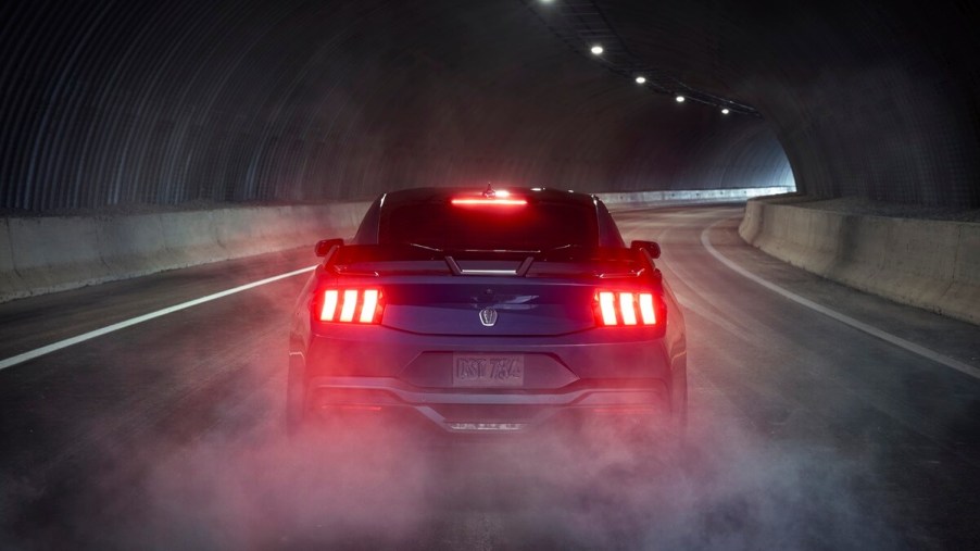 A new 2024 Ford Mustang Dark Horse in a dark tunnel with rear lights illuminated.