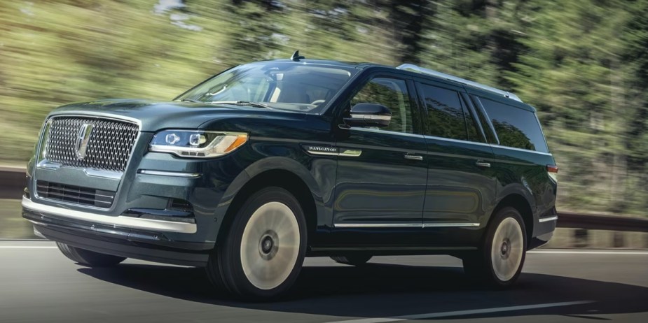 A gray 2024 Lincoln Navigator is driving on the road. 