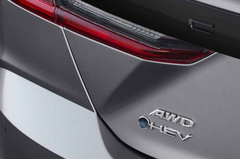 The right rear corner of a charcoal 2025 Toyota Camry XSE is shown with AWD and HEV badges