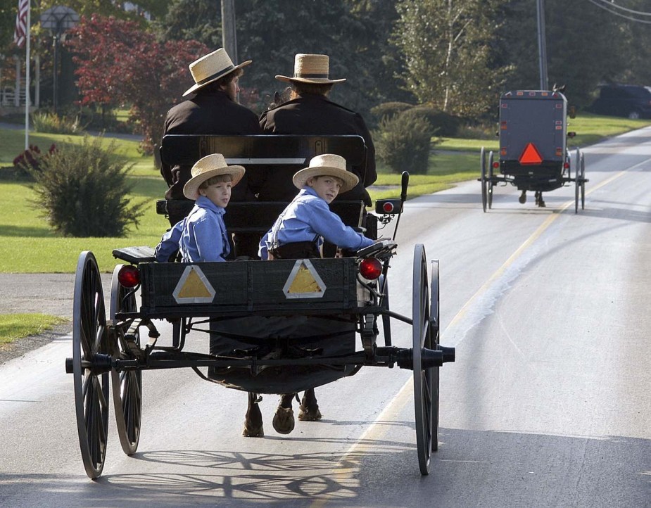 An Amish family travels down the road in their buggy.