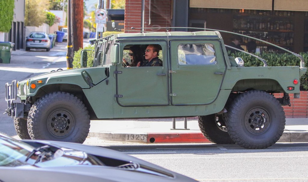 Bodybuilder/actor/governor Arnold Schwarzenegger drives an Army green Hummer SUV through Los Angelese.