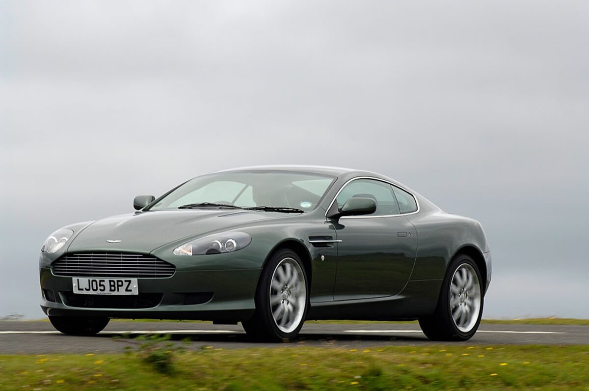 A DB9 shows off its aesthetic by looking like a James Bond 007 car or Johnny English GT on a grassy field.