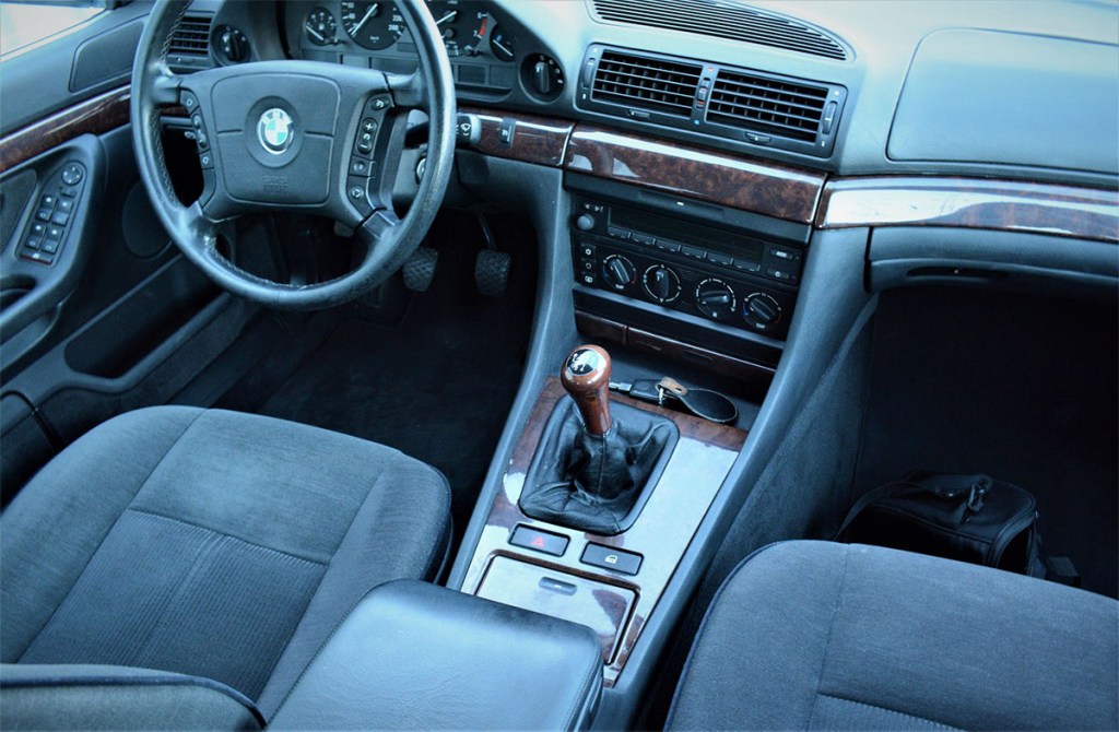 1994 BMW 730i E38 7 series Base Model interior showing manual transmission shift knob, base model stereo, and steering wheel with gray cloth seats