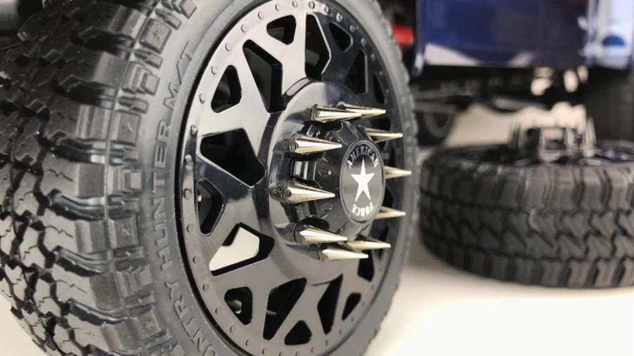 The spiked lug nuts on the aftermarket rims of a lifted pickup truck.