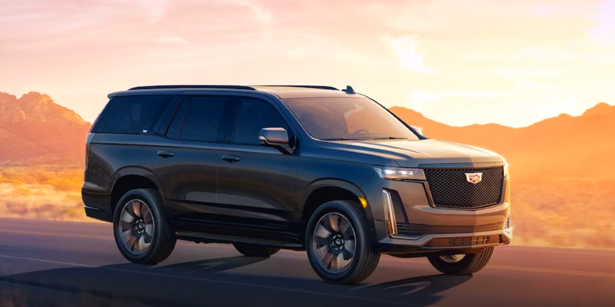 A gray 2024 Cadillac Escalade ESV large luxury SUV is driving.
