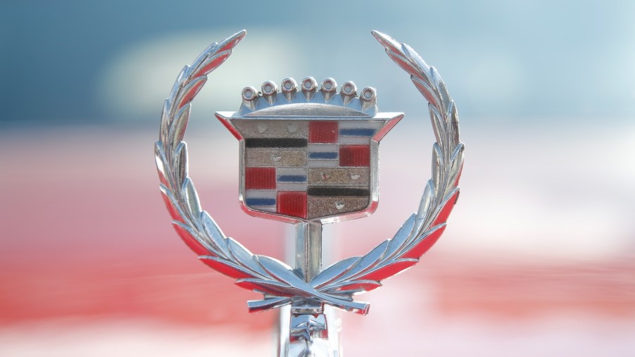 The hood emblem on a red Cadillac shows the crest of the founder of Detroit.