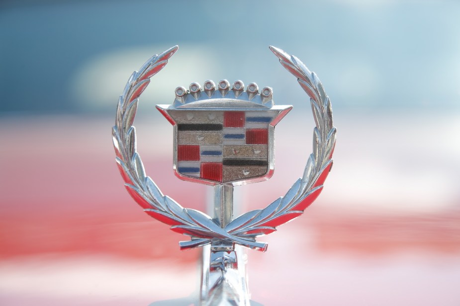 The hood emblem on a red Cadillac shows the crest of the founder of Detroit.