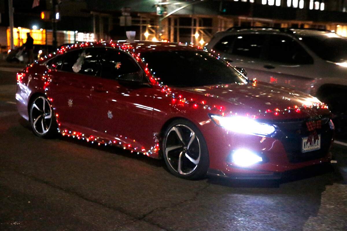 A red car decorated with Christmas lights in New York City