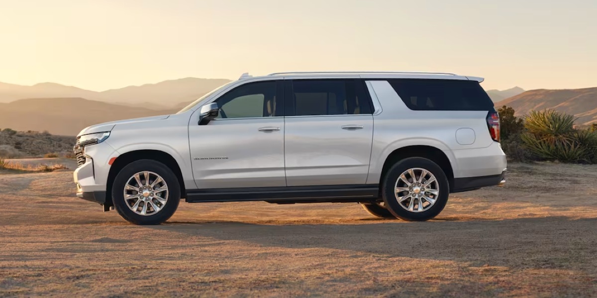 A white 2023 Chevrolet Suburban full-size SUV is parked.