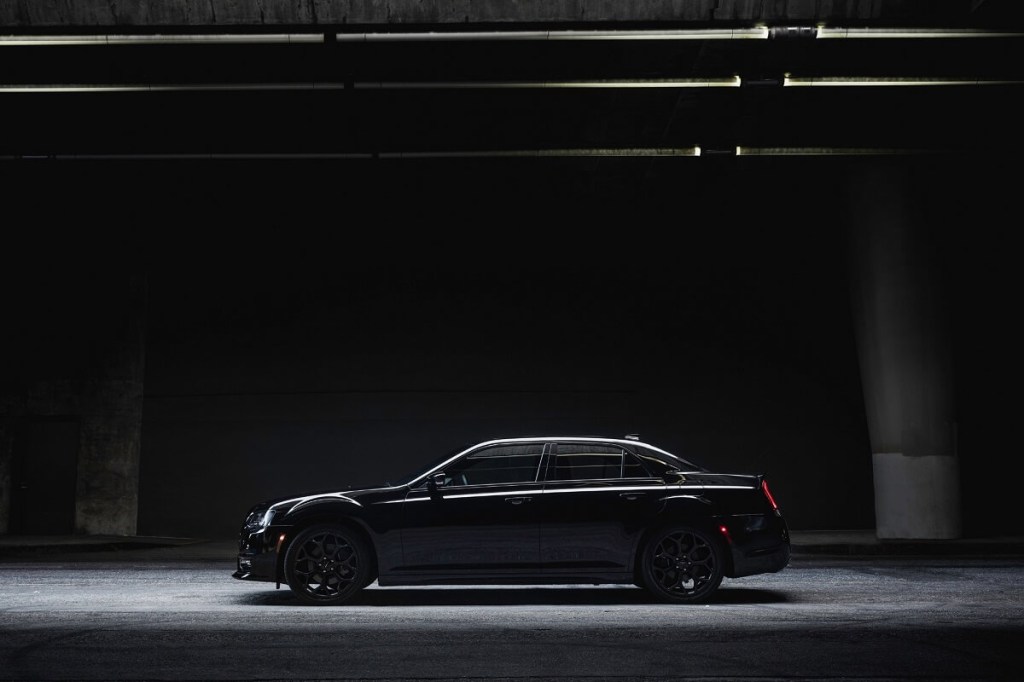 A black Chrysler 300 sits under dim lights. 